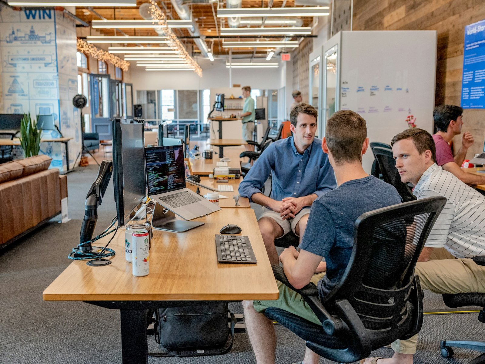 Business team talking at their desks in an open office