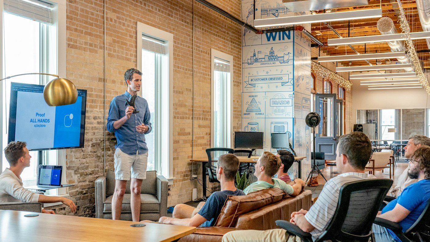 Speaker presenting to a team in an open-plan office