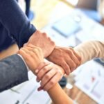 Business partners joining hands over a desk